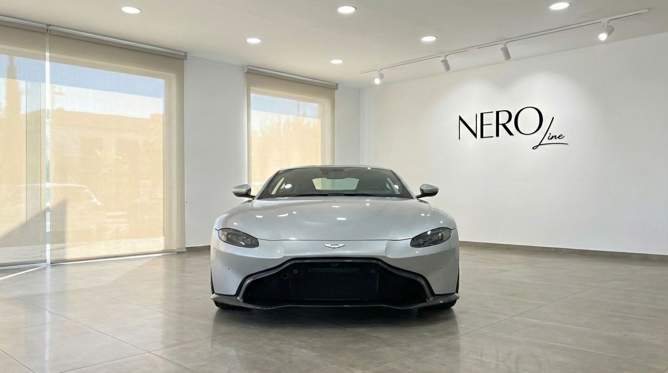 The silver grey Aston Martin Vantage V8 is showcased in a showroom, presenting its sleek front design in Marbella.