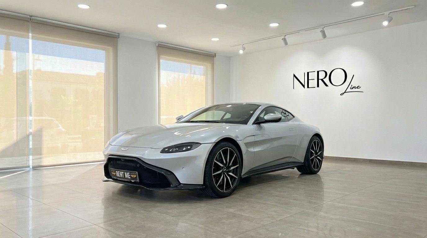 A silver-grey 2019 Aston Martin Vantage V8 is showcased from a front three-quarter view in a bright Marbella showroom.
