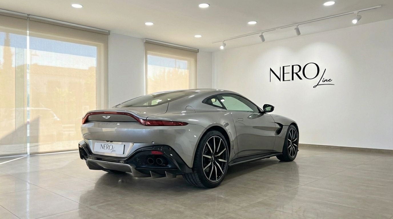 The silver-grey 2019 Aston Martin Vantage V8 is showcased from a rear three-quarter angle in a Marbella showroom.