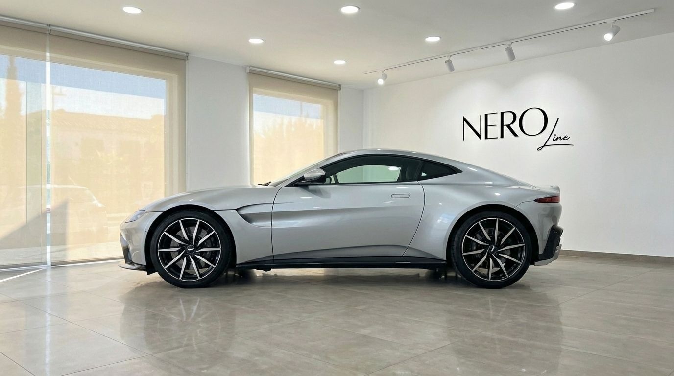 The silver grey 2019 Aston Martin Vantage V8 is showcased in a showroom with large windows in Marbella.