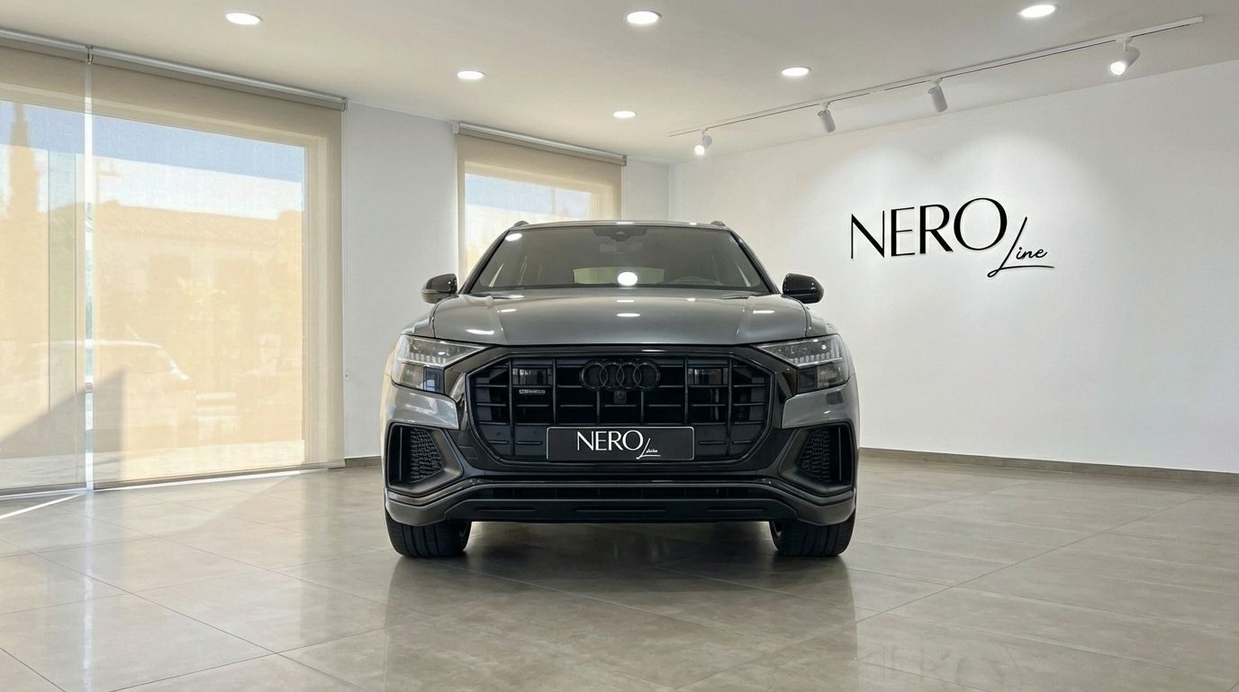 The matte gray Audi Q8 TDI is prominently displayed in a showroom, showcasing its bold front grille and headlights in Alicante.