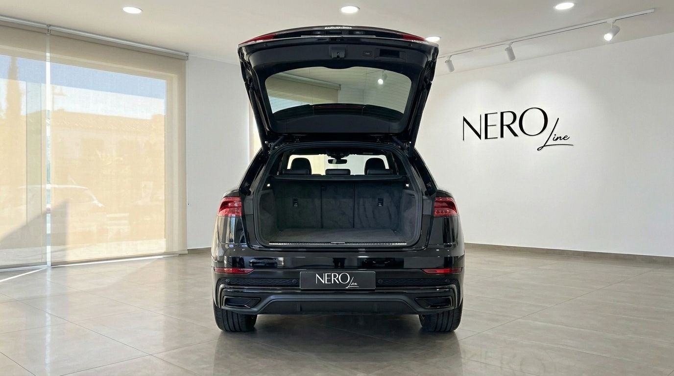 Vista trasera de un Audi Q8 S-line negro con el maletero abierto, mostrando el espacioso compartimento de carga en Marbella.