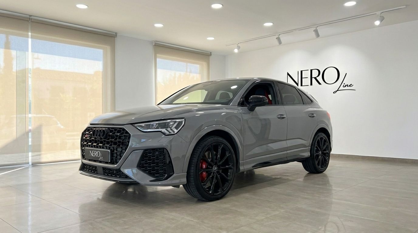 The 2022 Audi RS Q3 in gloss Nardo Grey is showcased from a front three-quarter view inside a luxury showroom in Marbella.