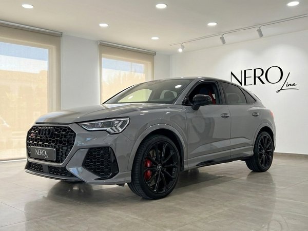 Audi RS Q3 – Luxury Performance SUV in Marbella The 2022 Audi RS Q3 in gloss Nardo Grey is showcased from a front three-quarter view inside a luxury showroom in Marbella.