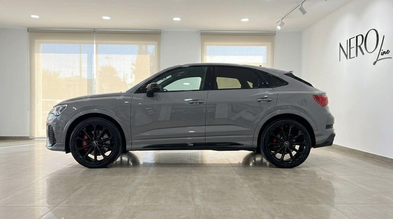 The 2022 Audi RS Q3 in gloss Nardo Grey, showcasing its sleek side profile inside a showroom in Marbella.