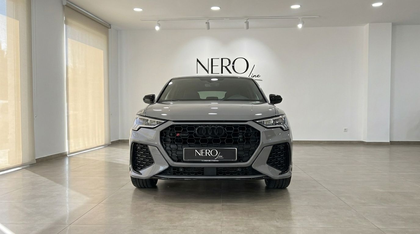 The Audi RS Q3 in gloss Nardo Grey is prominently displayed in a front view inside a showroom in Marbella.