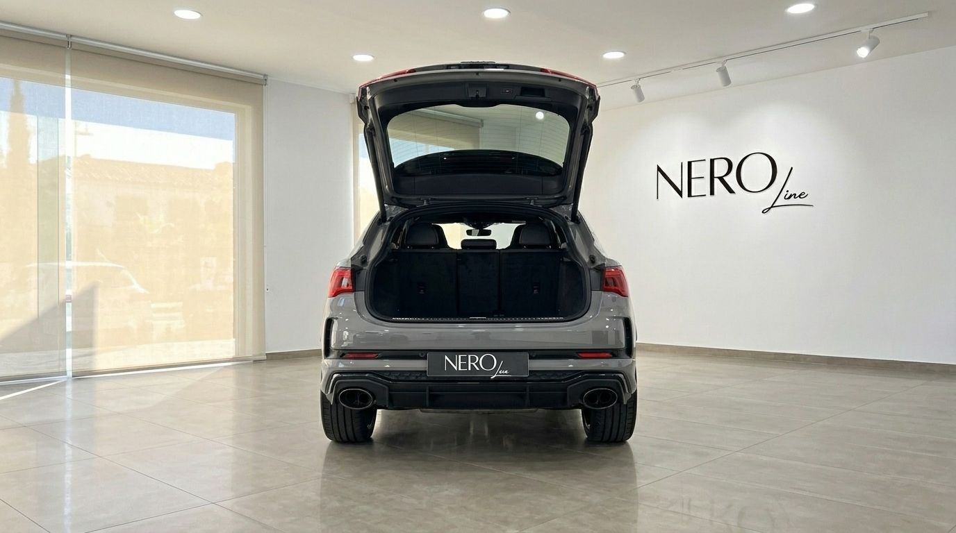The rear view of a grey Audi RS Q3 in Marbella, with its trunk open, showcasing the spacious cargo area.