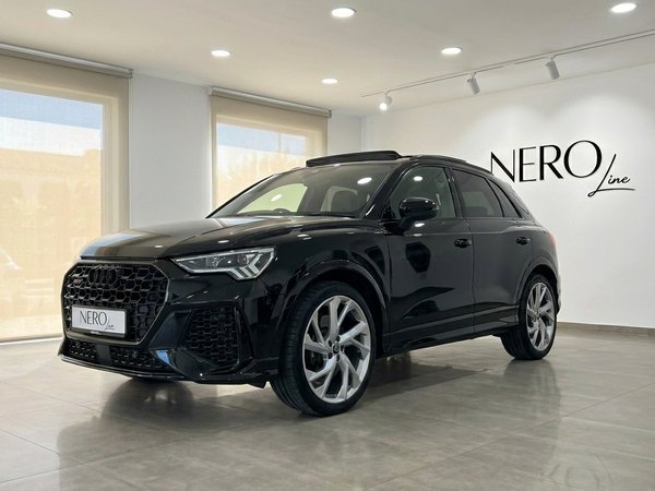 Audi RS Q3 — Front three-quarter view, Alicante The 2022 black Audi RS Q3 performance SUV is showcased from a front three-quarter angle in a bright Alicante showroom.