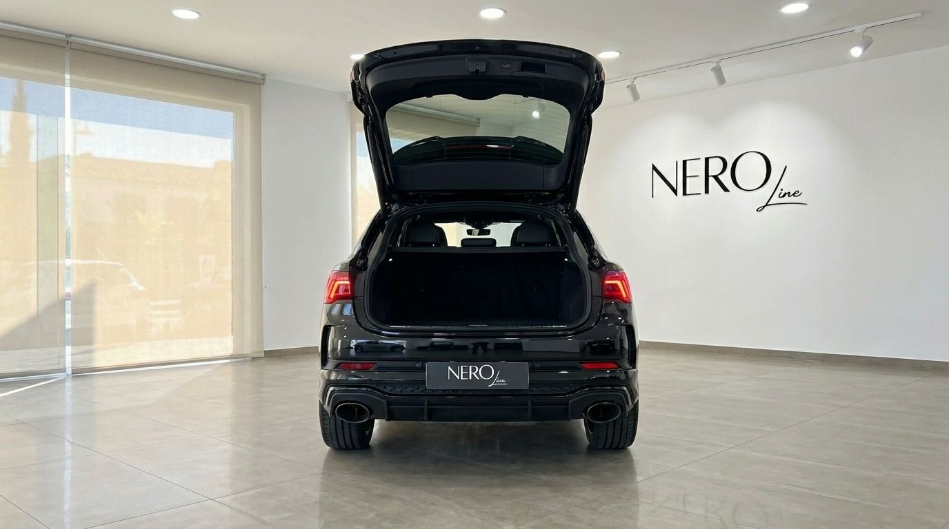 The black Audi RS Q3 2022 is shown from the rear with its trunk open in a showroom in Alicante.