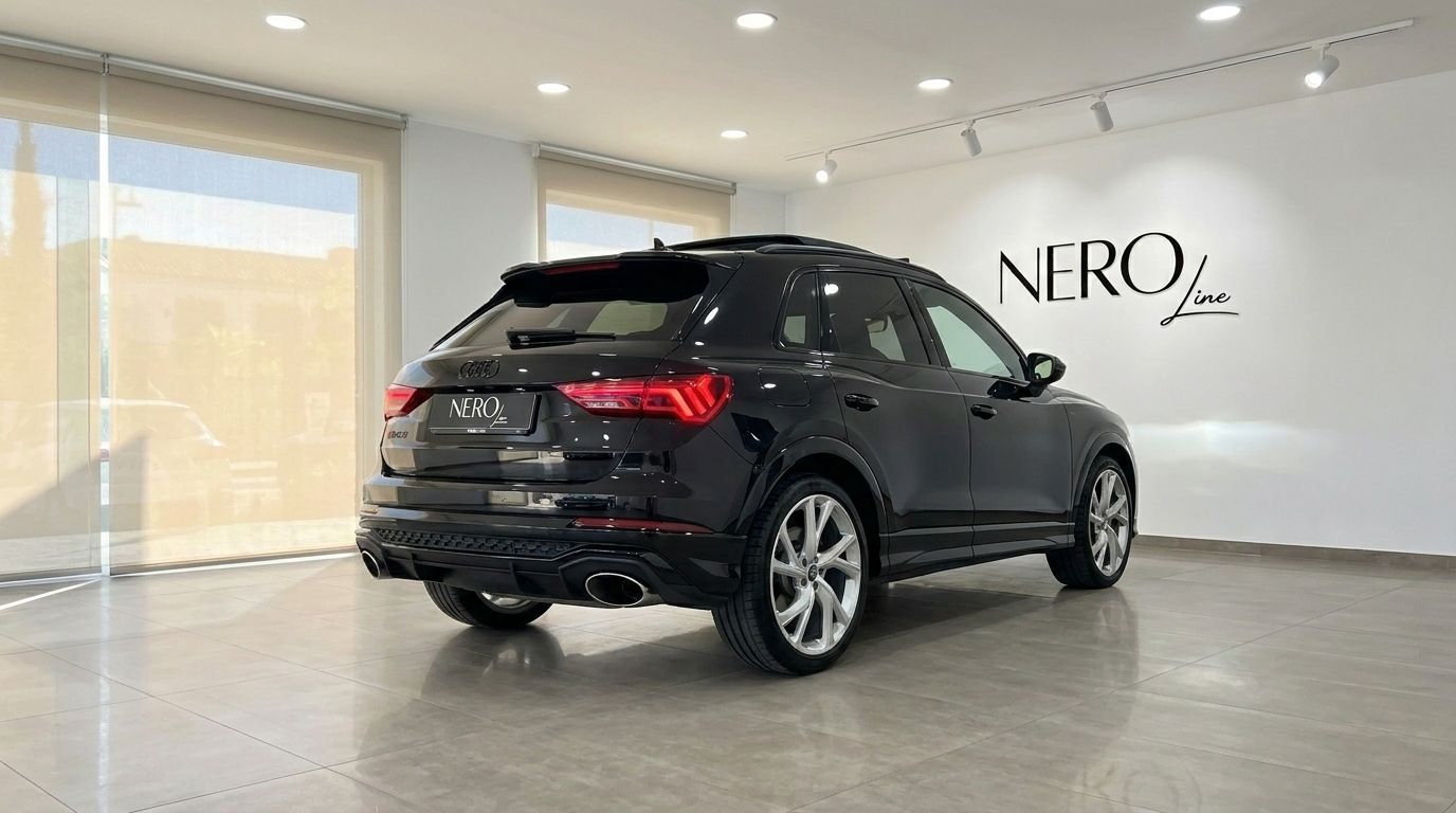 The black 2022 Audi RS Q3 is shown from a rear three-quarter angle inside a modern showroom in Alicante.