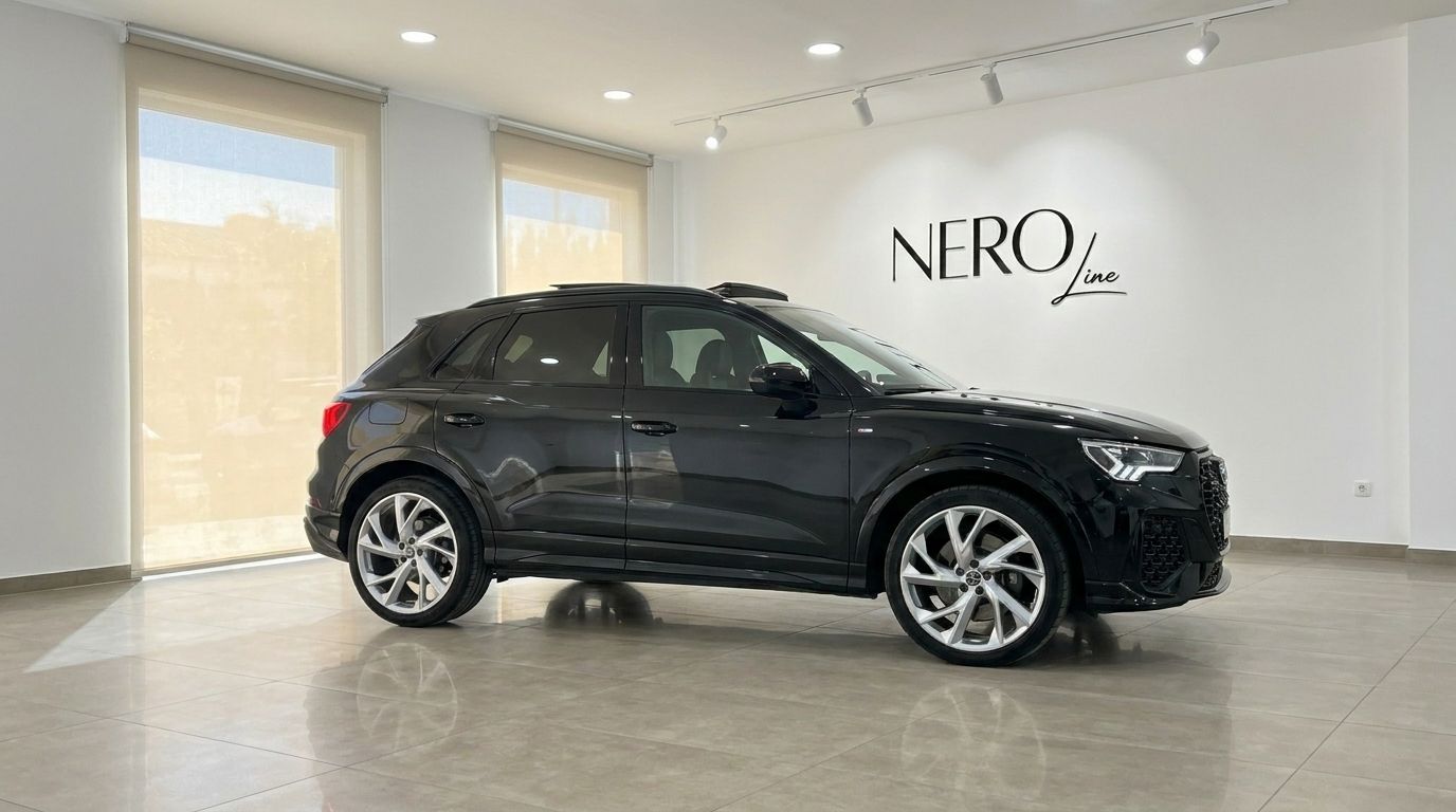 The black 2022 Audi RS Q3 is displayed from its side profile in a bright, modern showroom in Alicante.