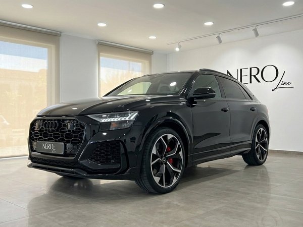 Audi RS Q8 — SUV de Luxe et Performance en Showroom L'élégant Audi RS Q8 noir de 2022 est présenté de trois quarts avant dans un showroom moderne Nero Line à Marbella.