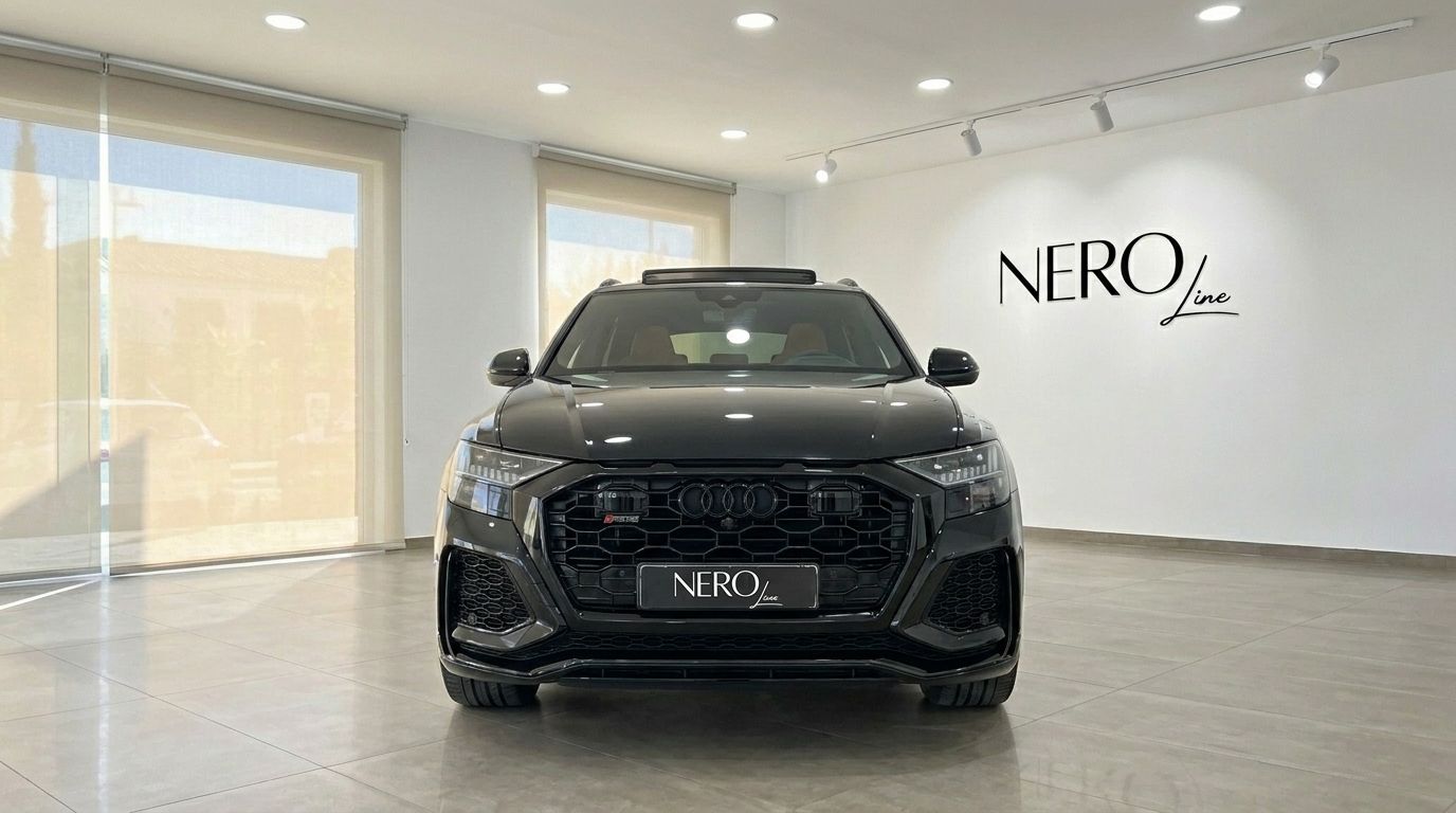 L'élégant Audi RS Q8 noir de 2022 est exposé de face dans un showroom de luxe à Marbella.