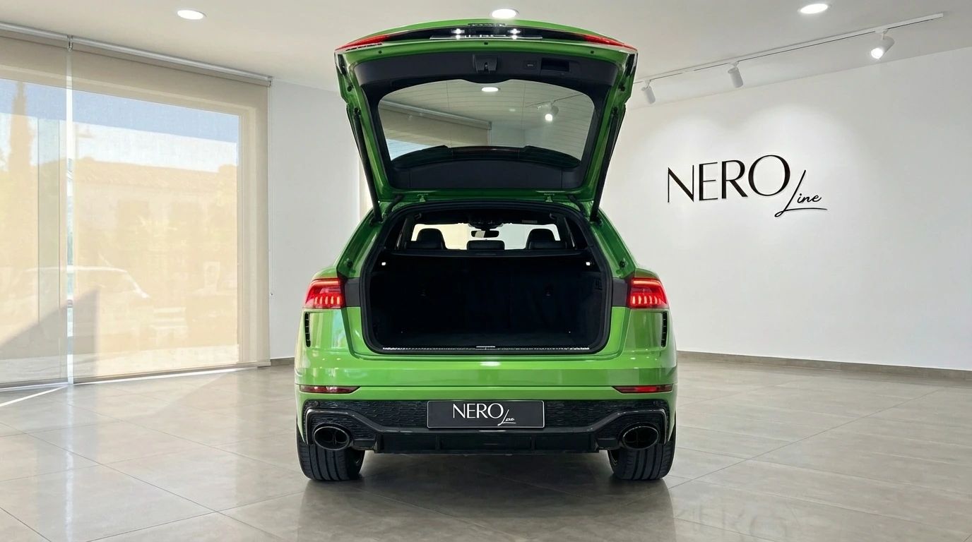 El Audi RS Q8 verde neón se muestra desde la parte trasera con el maletero abierto, aparcado en un concesionario en Madrid.