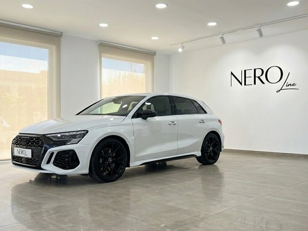 Audi RS3 — Front three-quarter view in Marbella The pearl white Audi RS3 is showcased from a front three-quarter angle in a modern Nero Line showroom in Marbella.