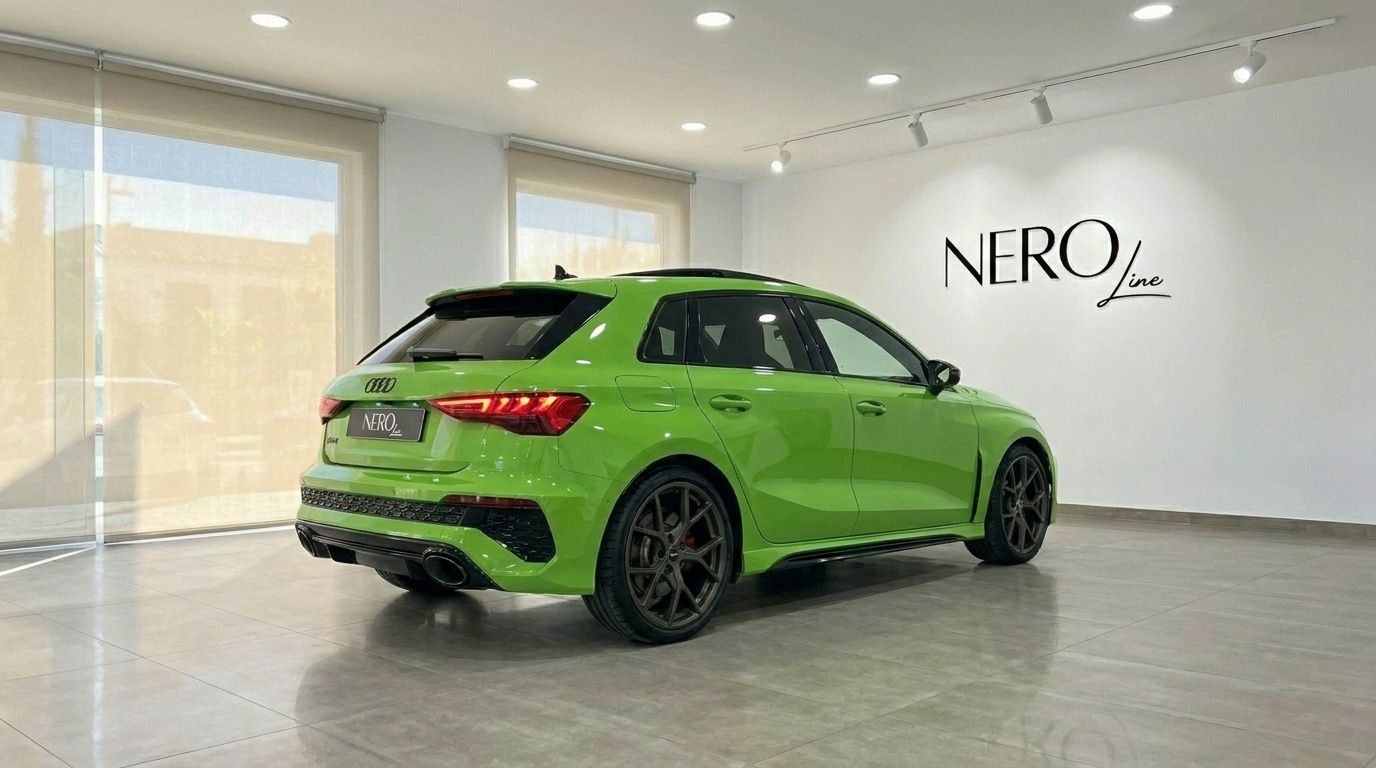L'Audi RS3 Sportback vert Kyalami brillant est vue de trois quarts arrière dans un showroom lumineux à Marbella.