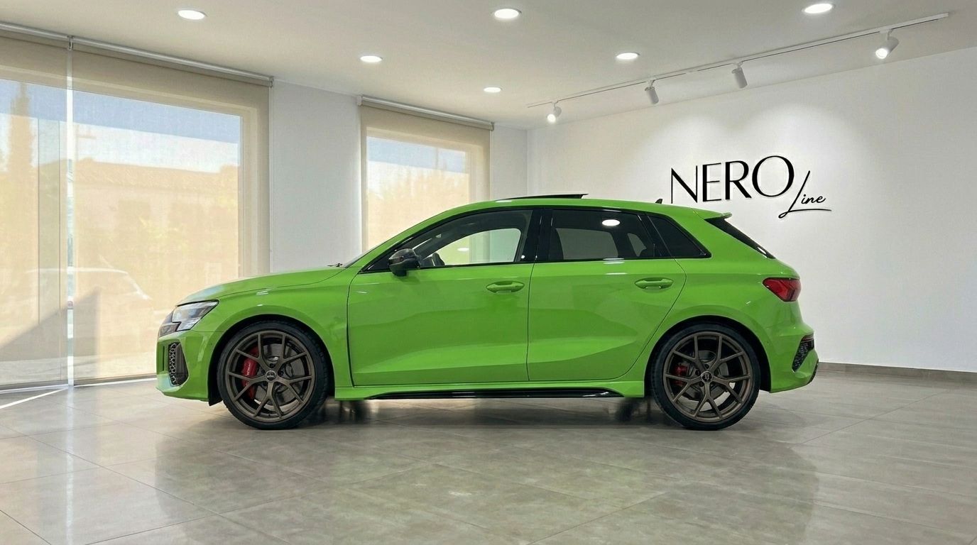 L'Audi RS3 Sportback vert Kyalami brillant est présentée de profil latéral à l'intérieur d'un showroom à Marbella.