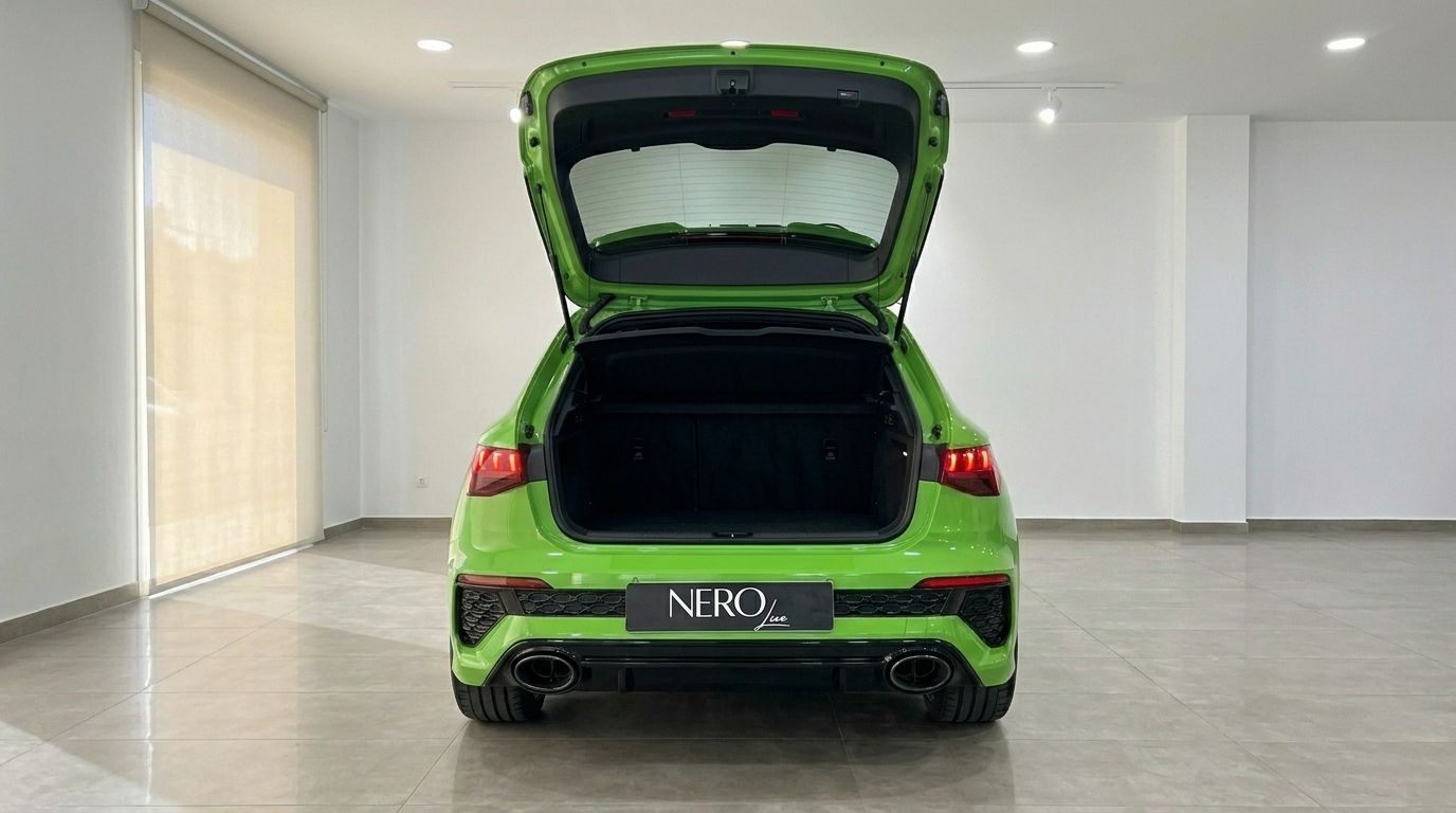 Vue arrière de l'Audi RS3 Sportback vert Kyalami brillant avec son coffre ouvert, présentant l'espace de chargement à Marbella.
