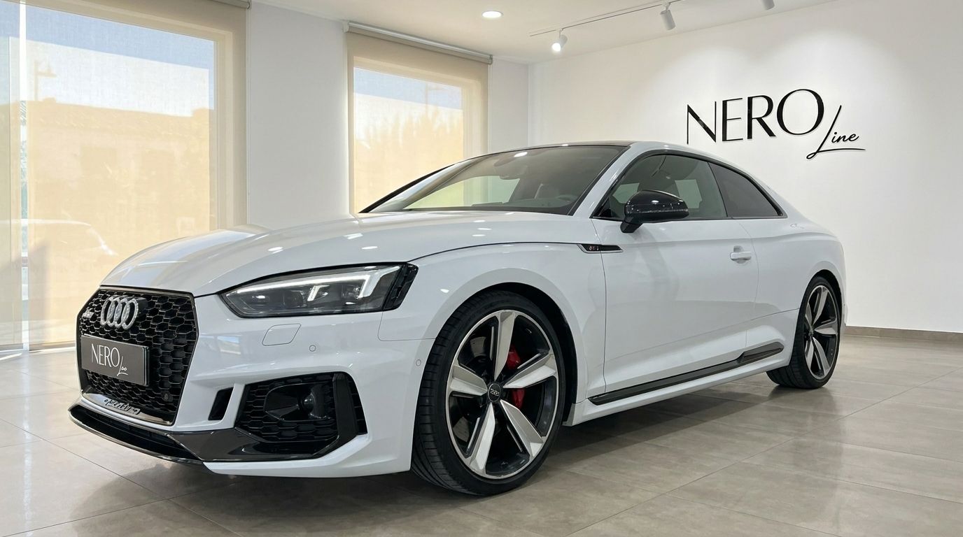 The white 2021 Audi RS5 is showcased from a front three-quarter angle in a showroom in Alicante.