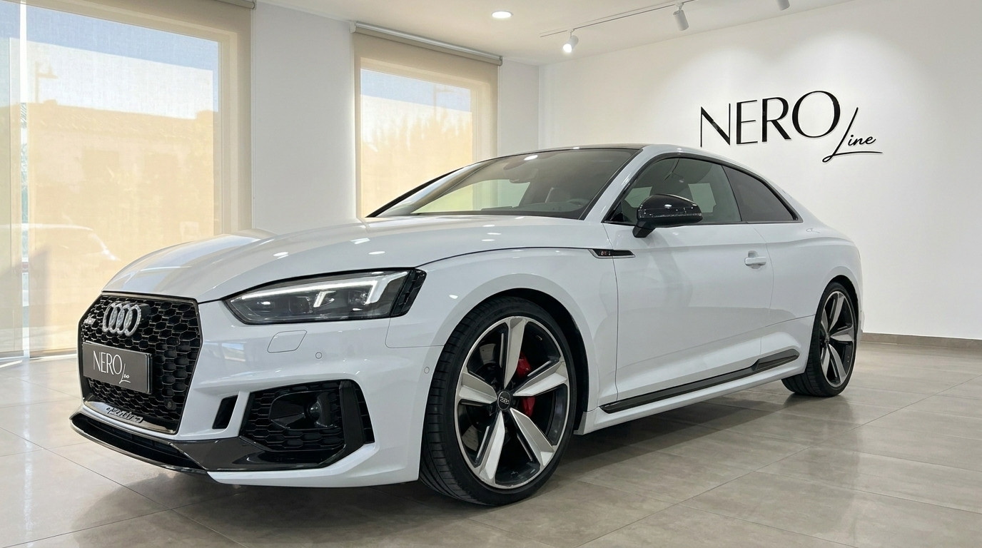 Audi RS5 — Front three-quarter view in Alicante The white 2021 Audi RS5 is showcased from a front three-quarter angle in a showroom in Alicante.