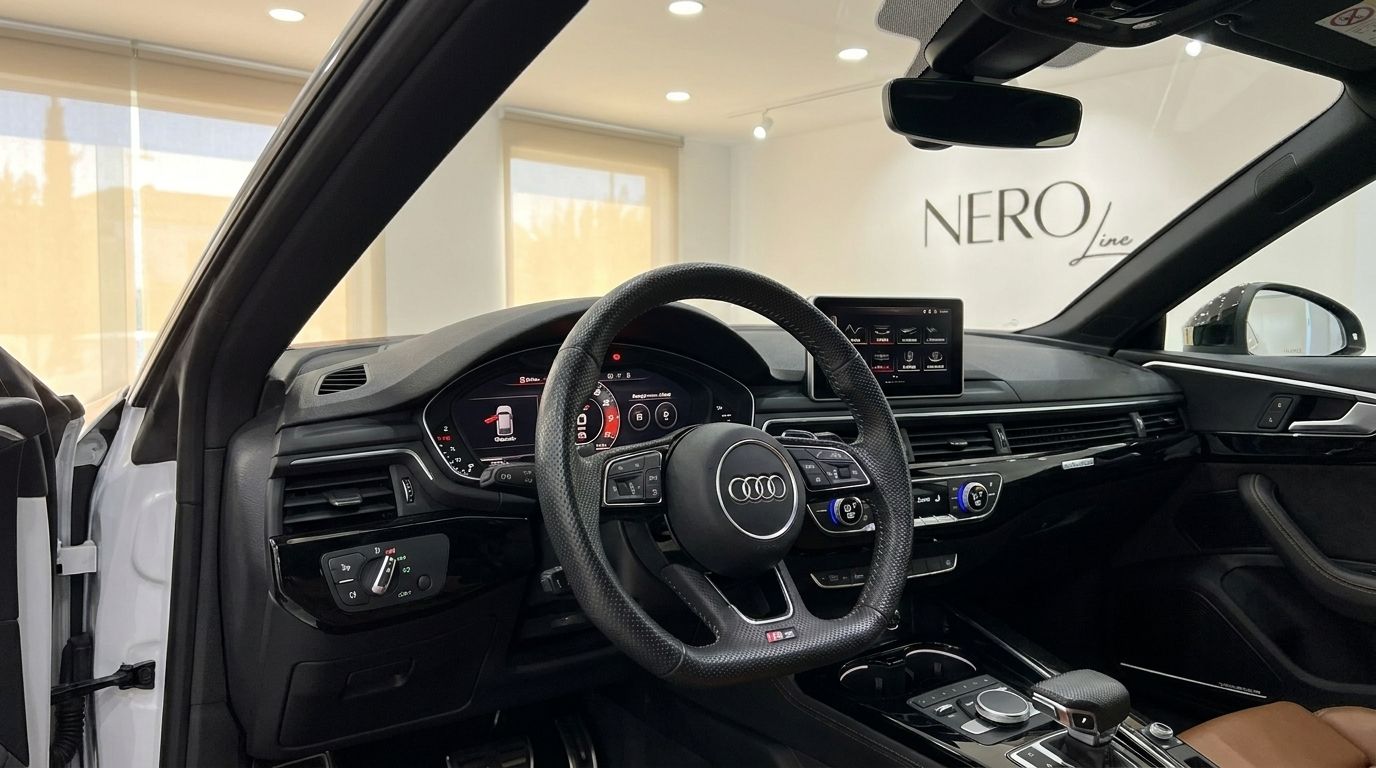 The luxurious cockpit of the 2021 Audi RS5 in Alicante, featuring its perforated leather steering wheel and digital dashboard.