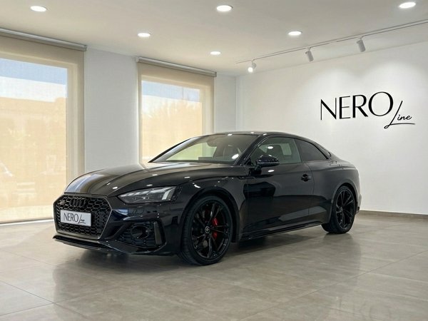 Audi RS5 — Luxury Sedan in Marbella Showroom The black 2025 Audi RS5 luxury sedan is showcased from a front three-quarter view in a Marbella showroom.