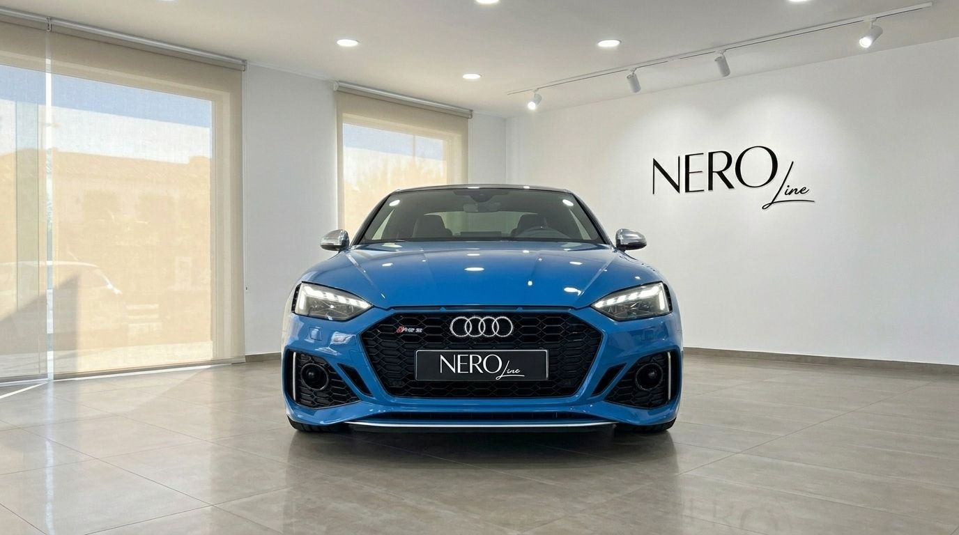 The blue 2020 Audi RS5 luxury car is showcased from a front view in a bright showroom in Alicante.
