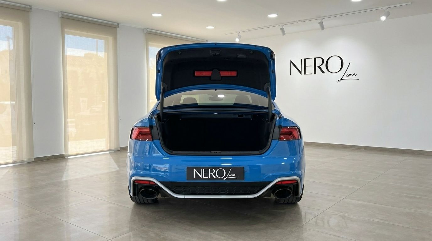The blue 2020 Audi RS5 is shown from the rear with its trunk open, highlighting the ample storage space in Alicante.