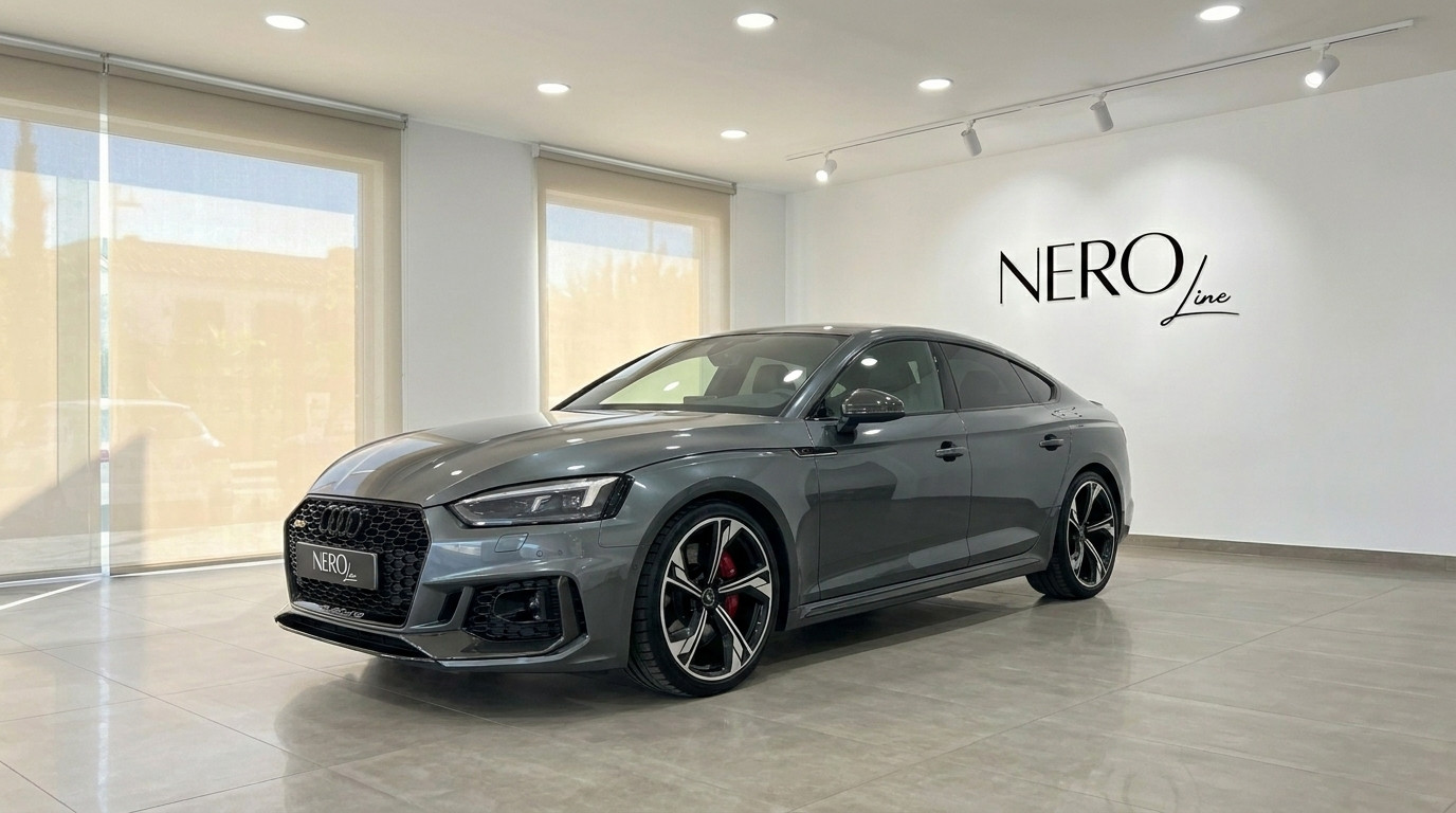 Audi RS5 Sportback — Front view in Benidorm showroom The metallic Daytona Gray Audi RS5 Sportback is showcased from a front three-quarter angle in a bright showroom in Benidorm.