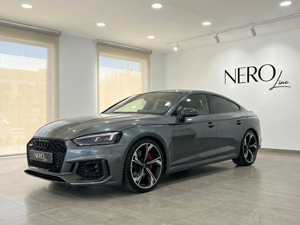Audi RS5 Sportback — Front view in Benidorm showroom The metallic Daytona Gray Audi RS5 Sportback is showcased from a front three-quarter angle in a bright showroom in Benidorm.