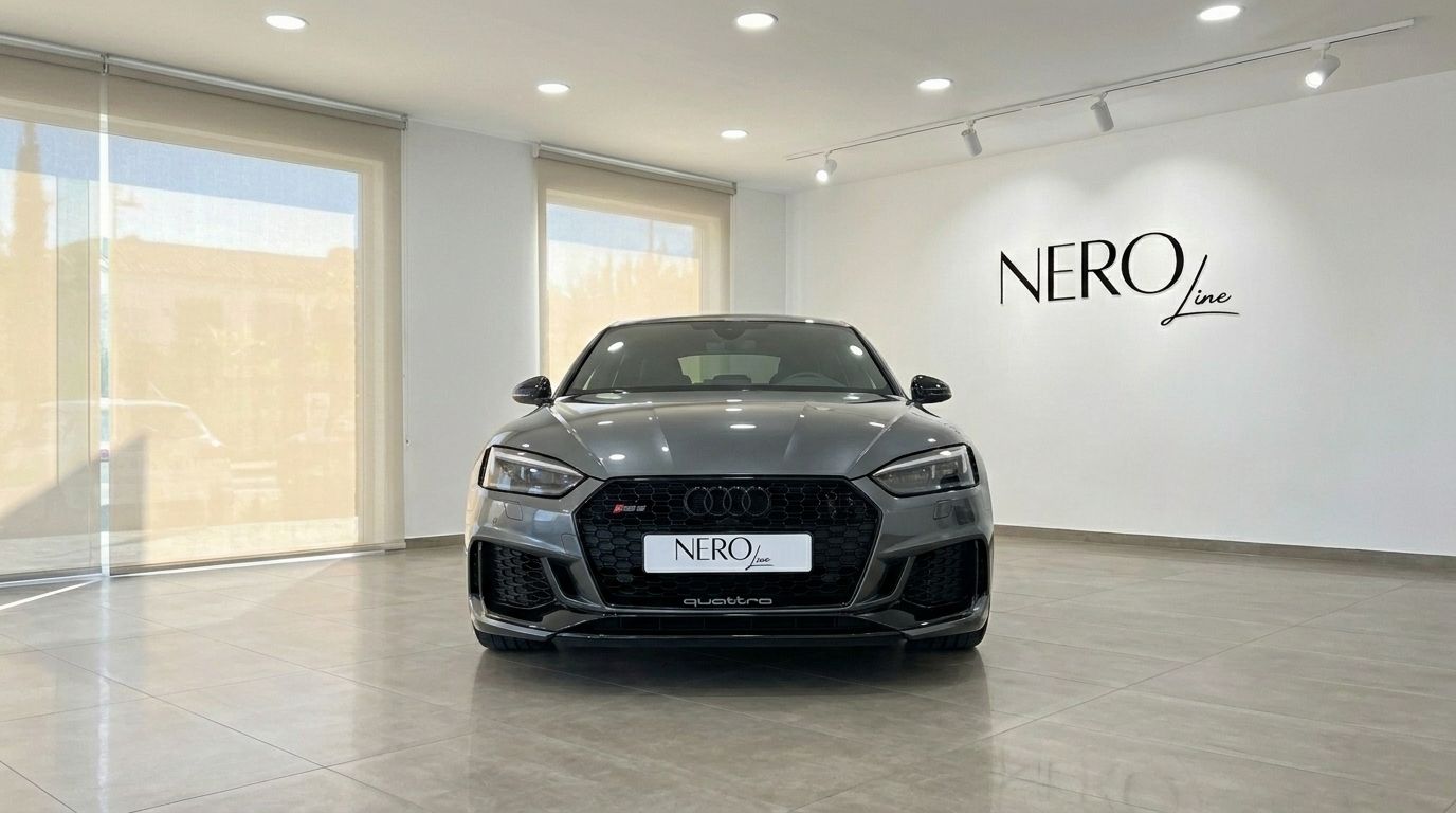 The metallic Daytona Gray Audi RS5 Sportback is showcased from the front in a showroom in Benidorm.