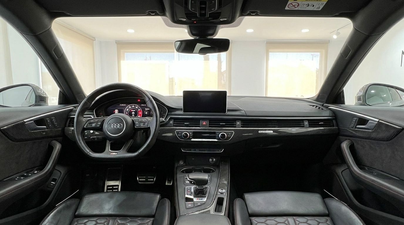 The luxurious interior of the Audi RS5 Sportback in Benidorm, showcasing the steering wheel, digital dashboard, and carbon fiber trim.