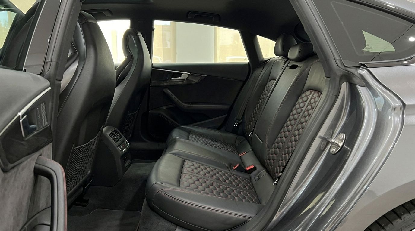 The rear interior of the Audi RS5 Sportback in Benidorm, featuring black leather seats with distinctive red honeycomb stitching.