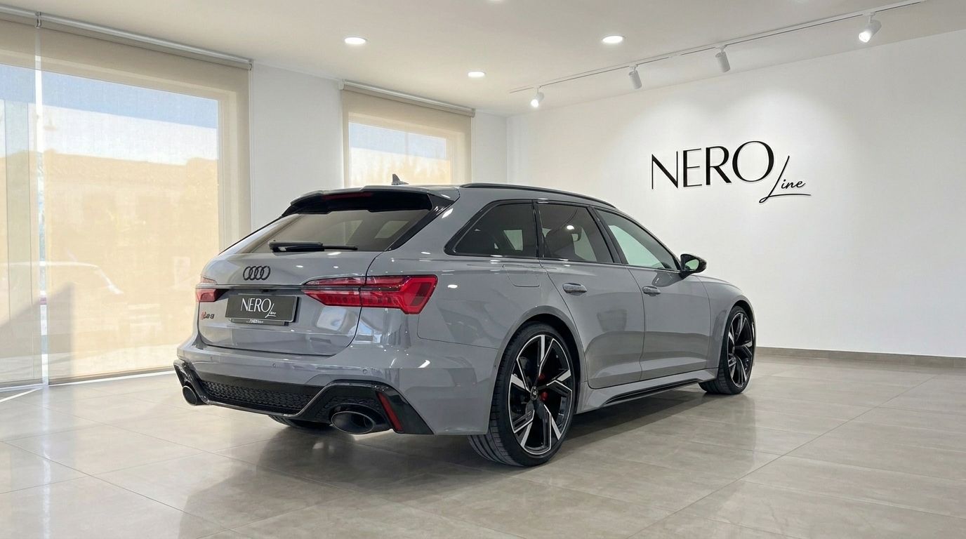 The gloss Nardo Grey 2026 Audi RS6 Avant is parked in a showroom, viewed from the rear three-quarter angle in Ibiza.
