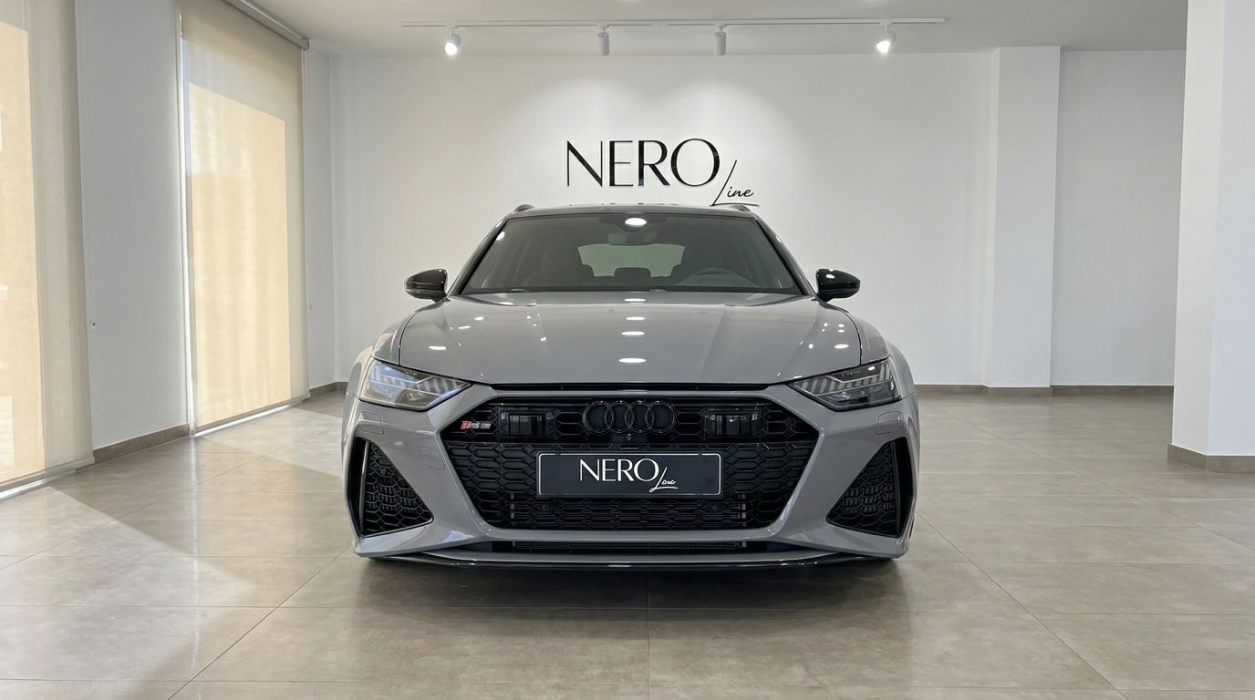 The gloss Nardo Grey Audi RS6 Avant is prominently displayed from the front in a modern showroom in Ibiza.