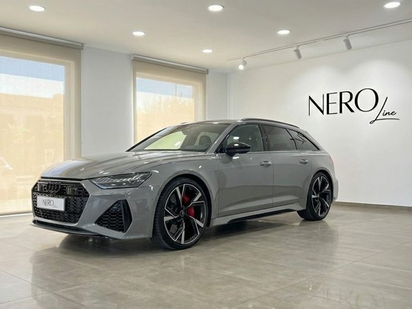 Audi RS6 Avant — Front view in Marbella showroom The matte gray Audi RS6 Avant, a luxury supercar, is showcased from a front three-quarter view in a bright Marbella showroom.