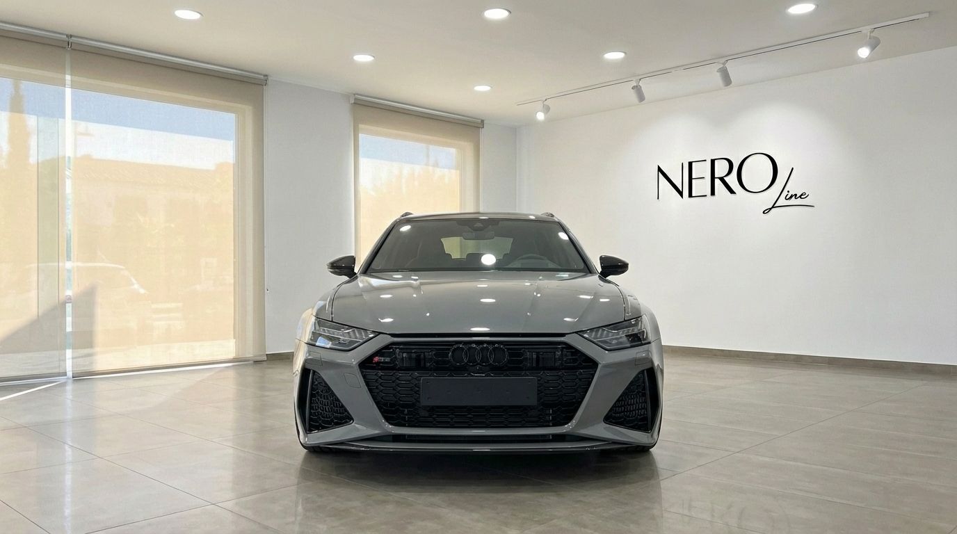 The matte gray Audi RS6 Avant is prominently displayed from the front in a showroom in Marbella.