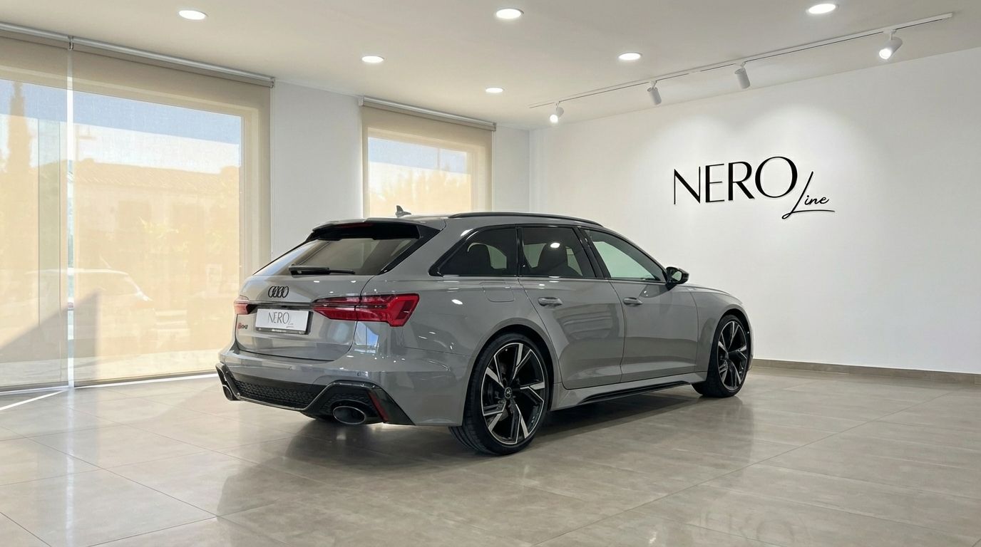 The matte gray Audi RS6 Avant is showcased from a rear three-quarter angle in a bright, modern showroom in Marbella.