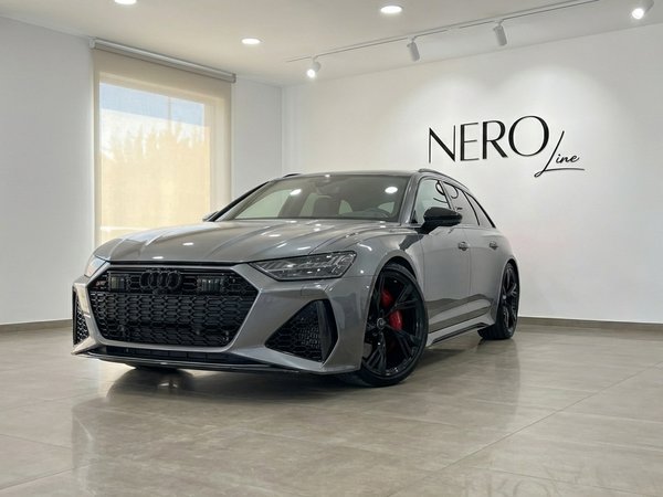 Audi RS6 Performance — Front three-quarter view The metallic gray 2025 Audi RS6 Performance is showcased in a showroom, captured from a front three-quarter angle in Marbella.