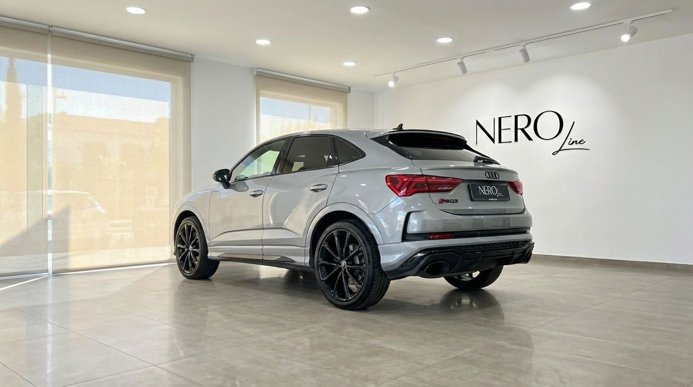 The metallic silver Audi RSQ3, showcasing its rear three-quarter view, is parked in a showroom in Barcelona with the Nero Line logo.
