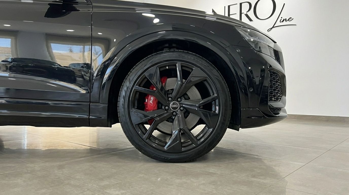 Primer plano de la llanta delantera negra multirradio y la pinza de freno roja del Audi RSQ8 en Madrid.