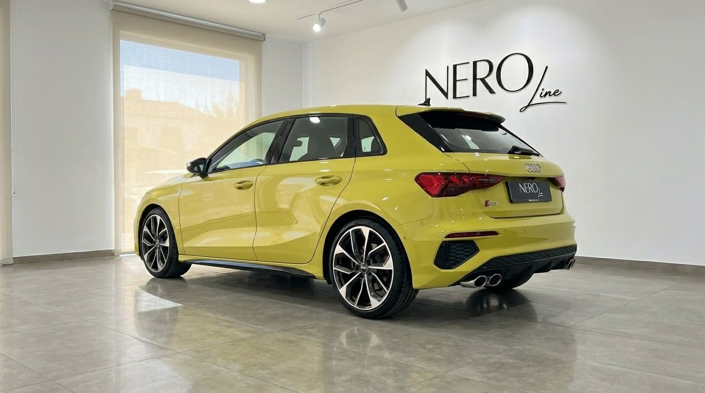 The gloss Python Yellow Audi S3 is showcased from the rear three-quarter angle in a showroom in Alicante.
