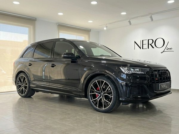 Audi SQ7 — SUV Performance à Marbella Le SUV de luxe Audi SQ7 2021 noir brillant est présenté de trois quarts avant dans un showroom à Marbella.