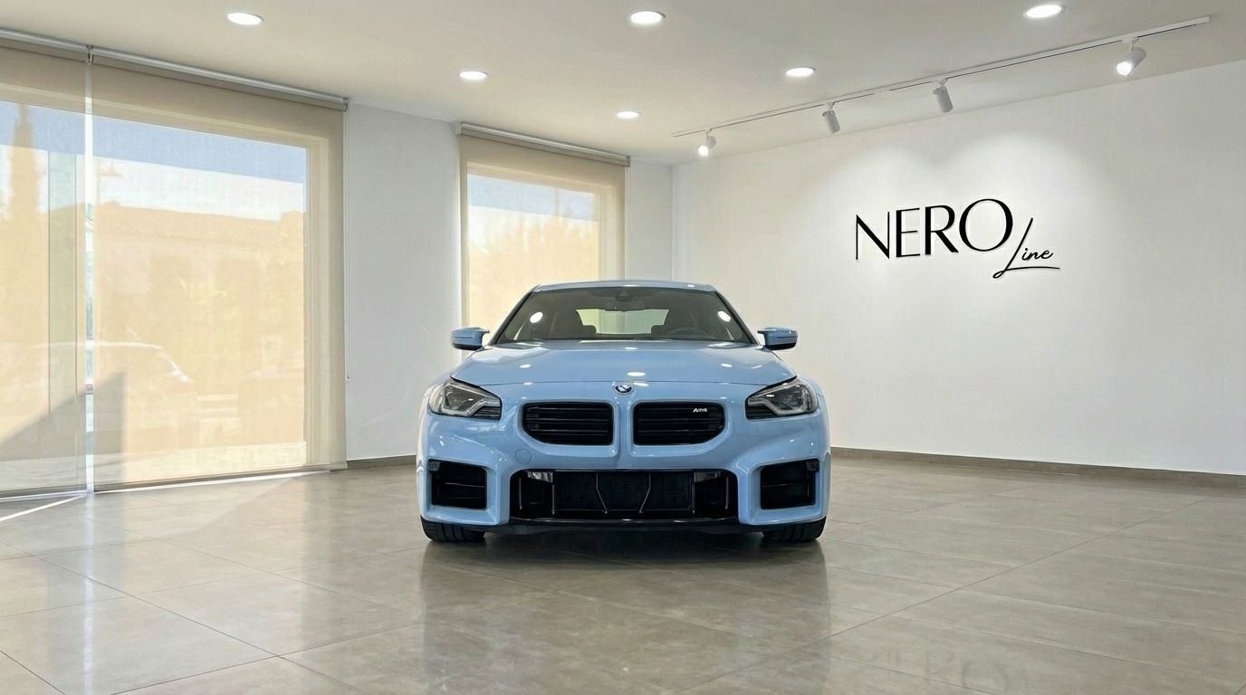 The light blue 2025 BMW M2 Competition is showcased from the front in a bright Alicante showroom.