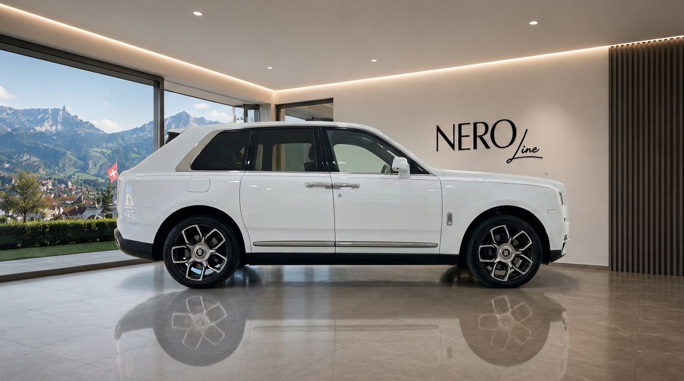 A gloss Arctic White Rolls Royce Cullinan is parked in a luxury showroom, with a panoramic view of the Swiss mountains and a village near Zurich.