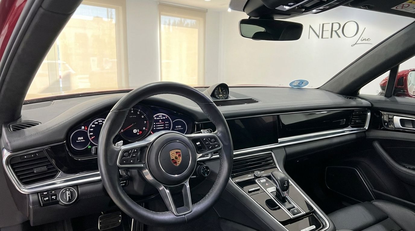 The interior of the Porsche Panamera 4S Hybrid in Alicante, showing the steering wheel, dashboard, and central console.
