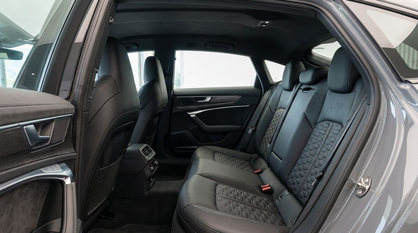 The Audi RS7's luxurious rear interior in Zurich, featuring black leather seats with distinctive honeycomb stitching and elegant door panels.