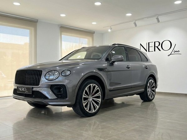 Bentley Bentayga — Vista tres cuartos delantera, Madrid El SUV de lujo Bentley Bentayga 2025 gris se exhibe en un concesionario con una vista tres cuartos delantera en Madrid.