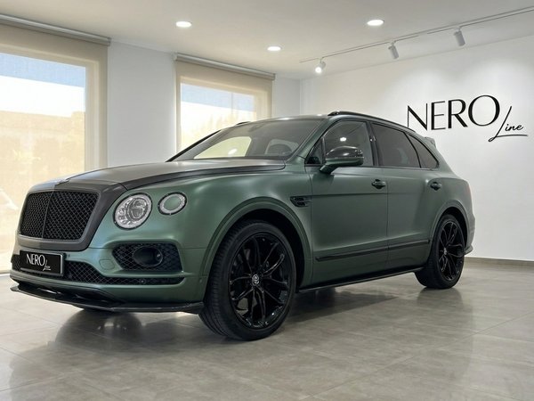 Bentley Bentayga — Elegant front view in Valencia The 2019 Bentley Bentayga in Satin British Racing Green, showcasing its elegant front three-quarter view in Valencia.
