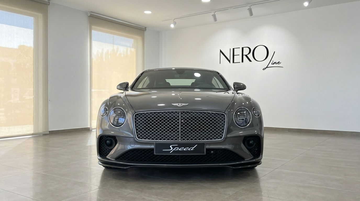 The gunmetal gray 2021 Bentley Continental GT Speed V12 is showcased from a front view in a luxury showroom in Alicante.